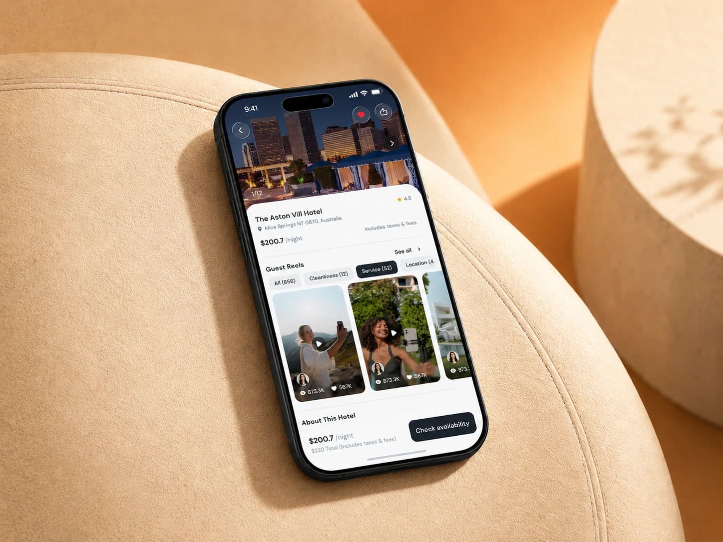 Lovo hotel detail screen with guest reels, on a phone resting on a beige lounge chair