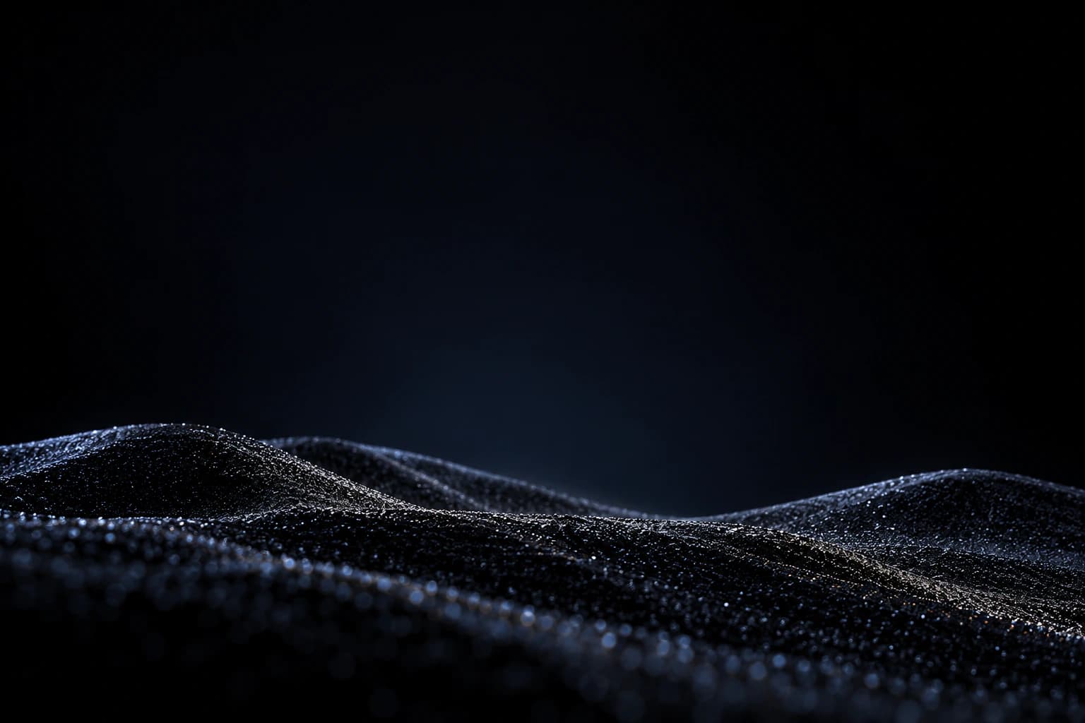 Dark ridges of sand in cool light.